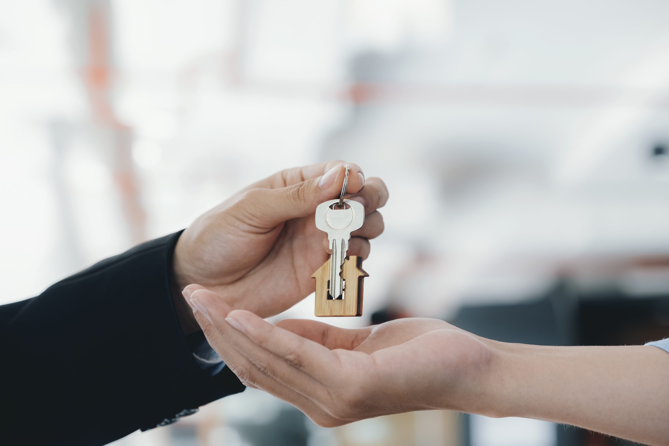 Deux mains qui s'échangent des clés de maison