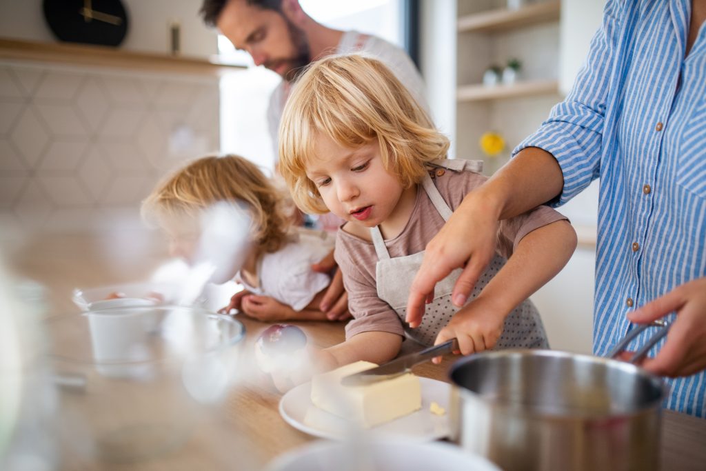 Deux enfants en train de cuisiner avec les parents